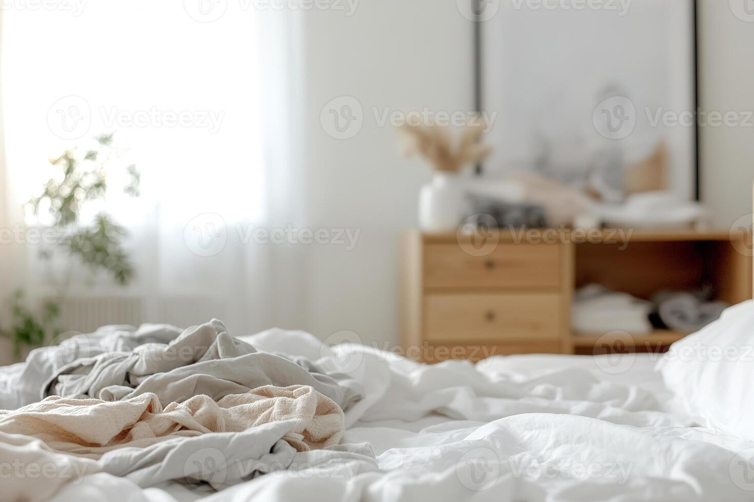 A bedroom shows signs of disarray with an unmade bed and clothes strewn across the floor, creating a lived-in feel. The clutter adds to the authentic charm of space, suggesting a need for tidying photo