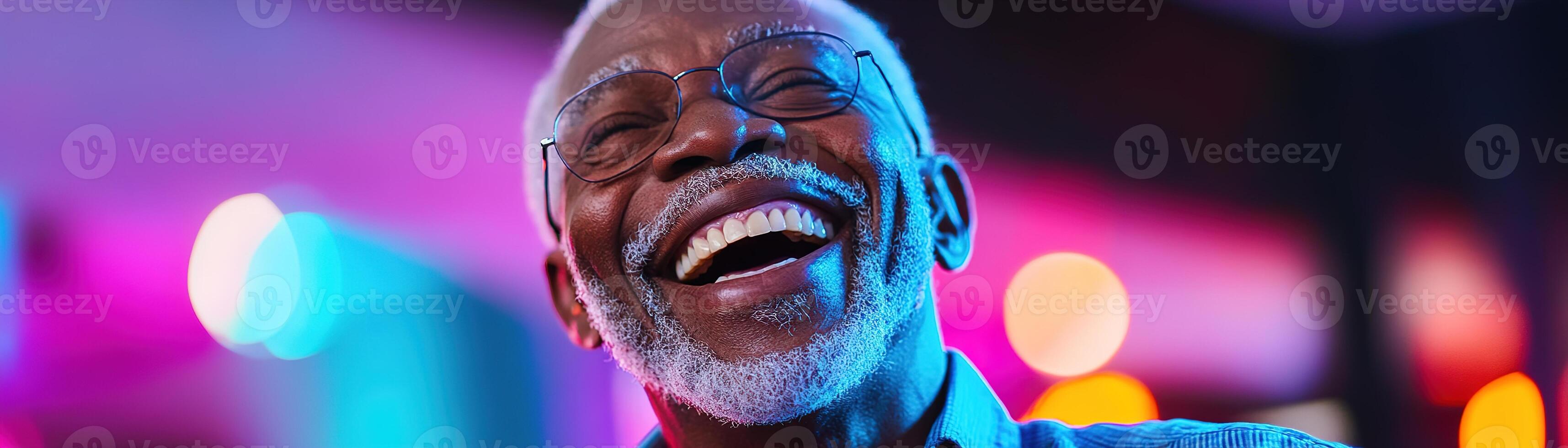 Senior man radiates joy with a wide laugh while dancing on a lively club floor, bathed in colorful lights, creating an enchanting atmosphere perfect for senior entertainment photo