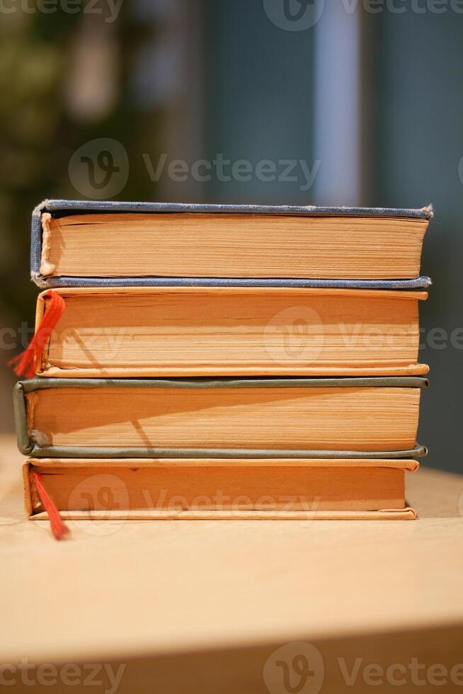 Stacked vintage books with colored spines on a wooden table photo