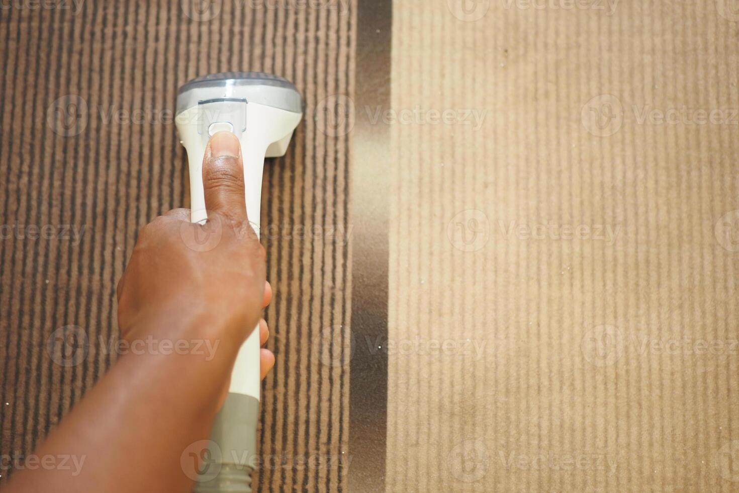 Handheld cleaner being used on carpet in a home setting photo