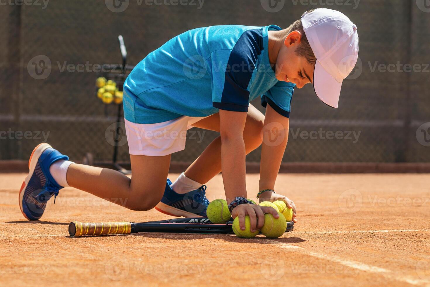 Little boy playing tennis on a dirt court photo