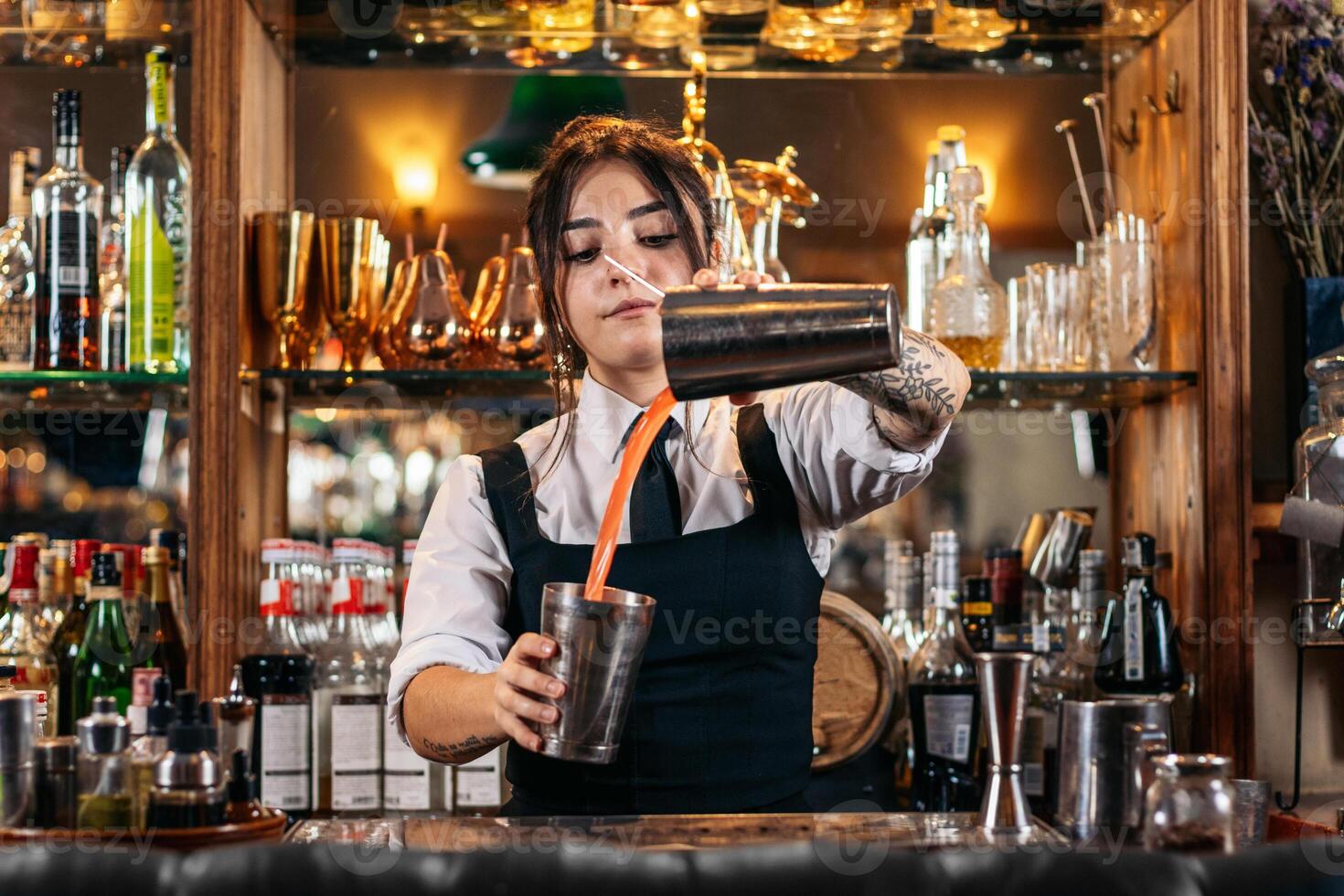 Female bartender preparing a cocktail in a traditional cocktail bar photo