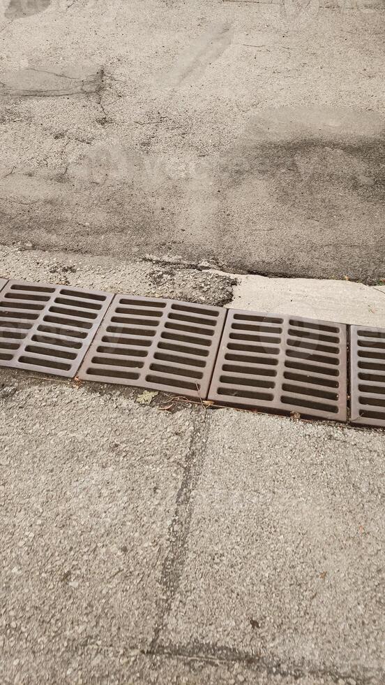 Rusty grate draining water on a sidewalk in cesky krumlov photo