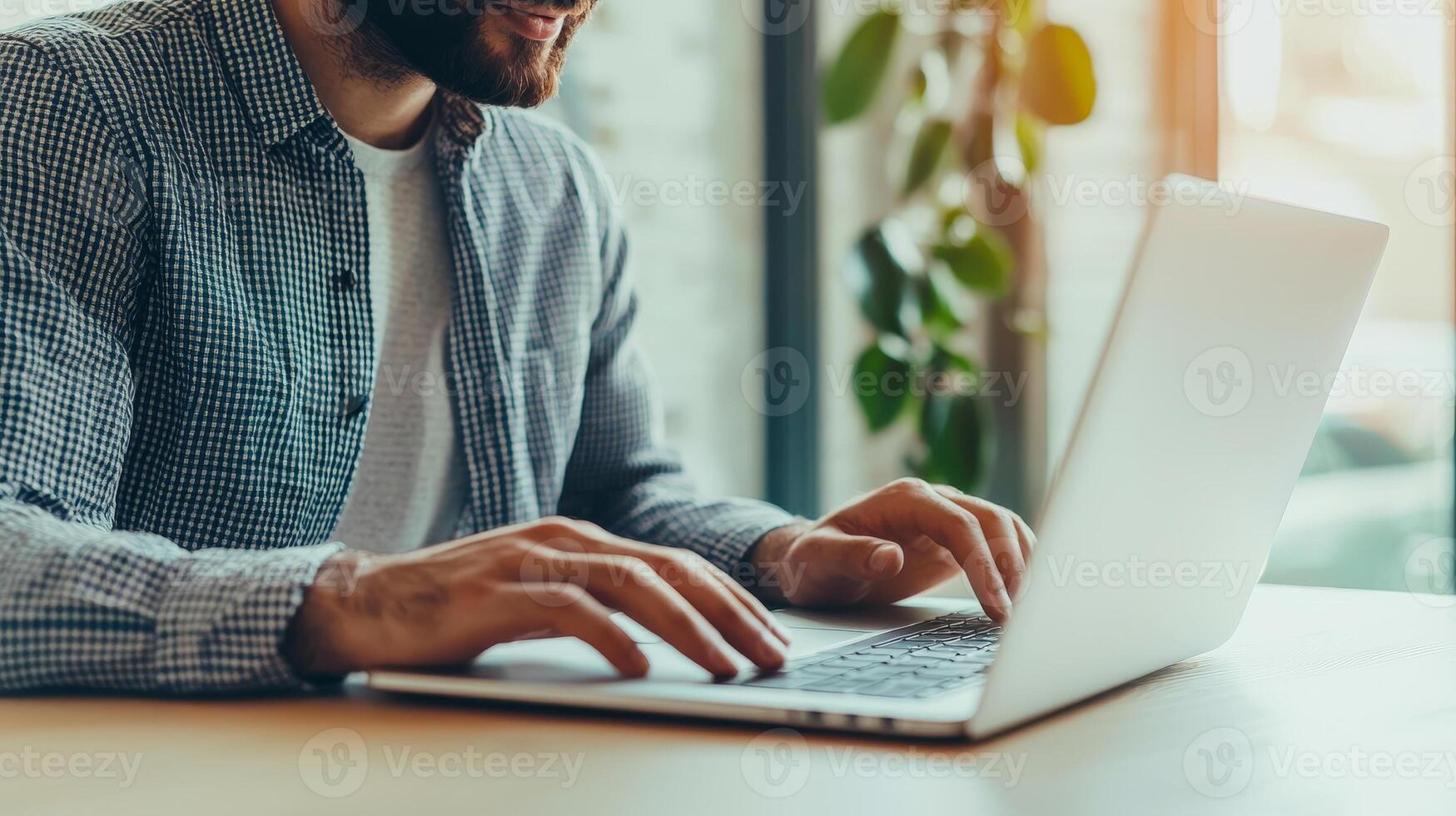 Digital transformation e-learning courses concept. A man typing on a laptop in a bright, modern workspace with plants nearby. photo