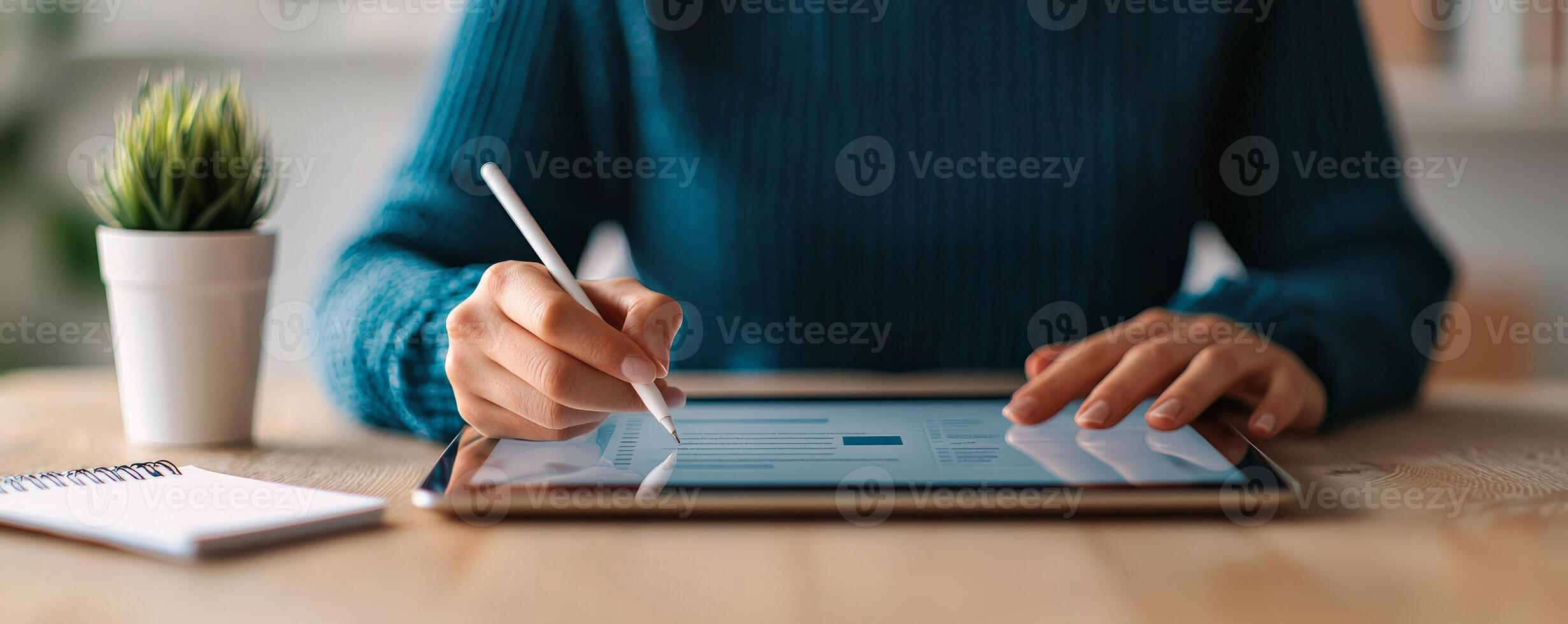 Digital transformation e-learning courses concept. A person using a tablet with a stylus, surrounded by a plant and a notepad on a table. photo