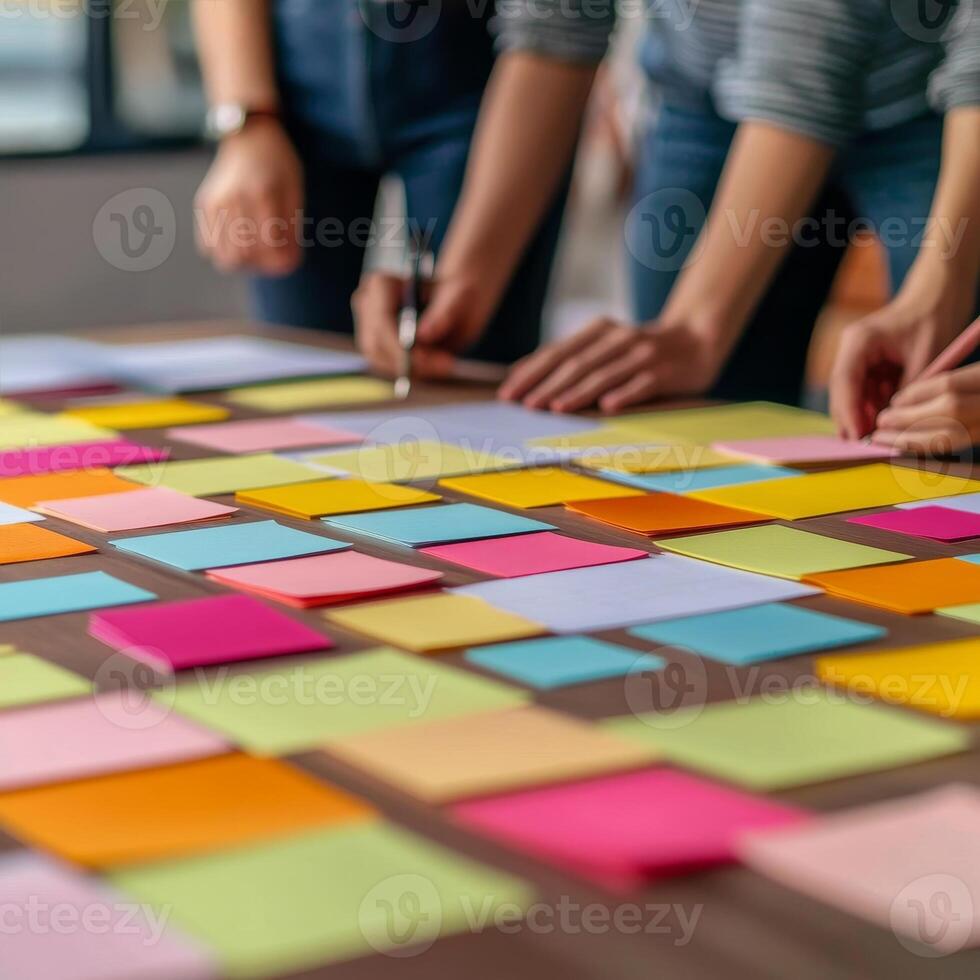 Startup brainstorming session concept. Hands arranging colorful sticky notes on a table in a collaborative workspace. photo