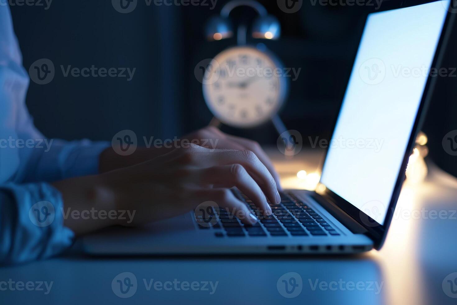 Inspirational success story motivation concept. Nighttime work scene with a person typing on a laptop beside a clock. photo