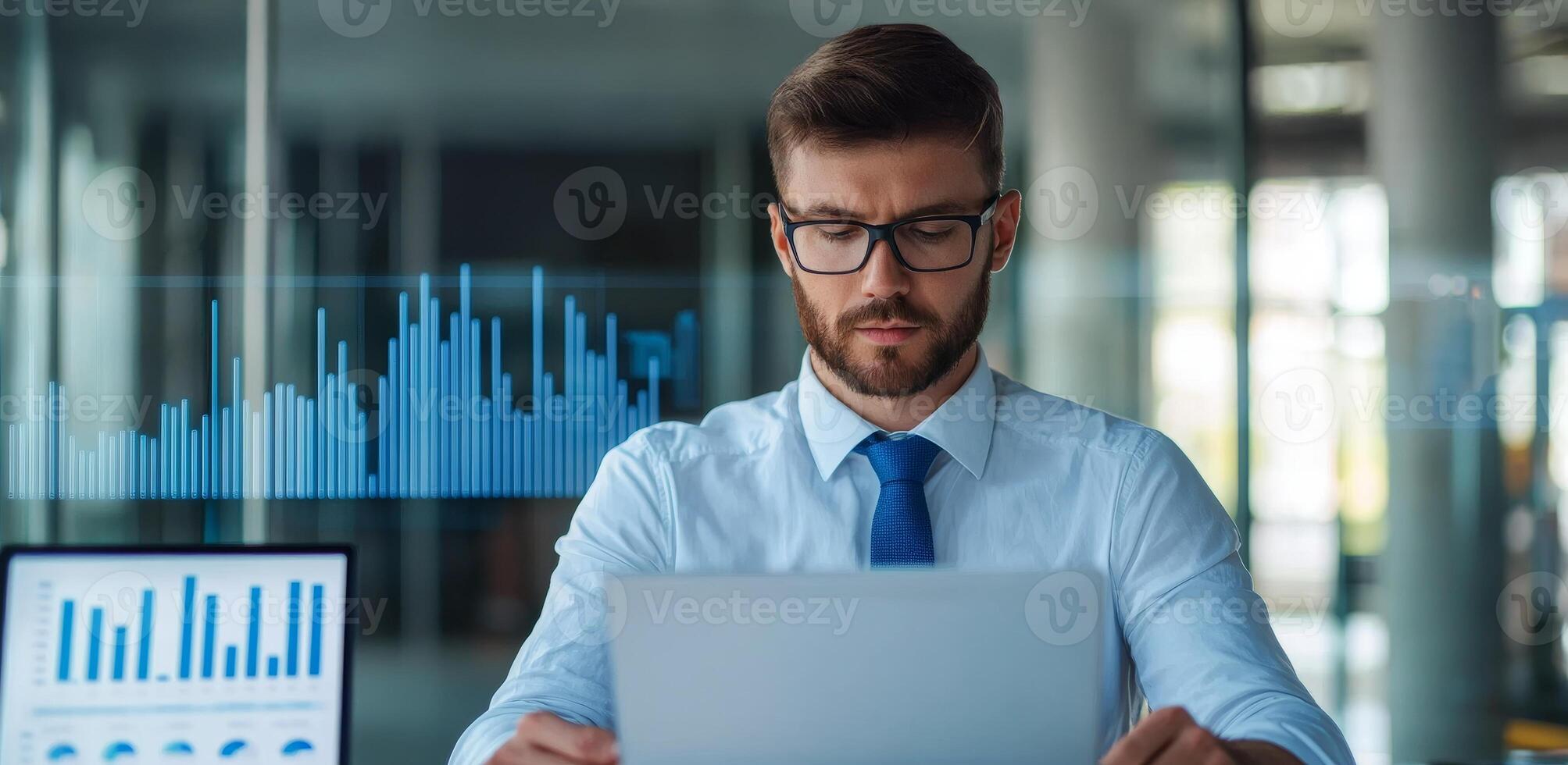 Data analytics and machine learning. Professional man analyzing data on a laptop in a modern office setting. photo