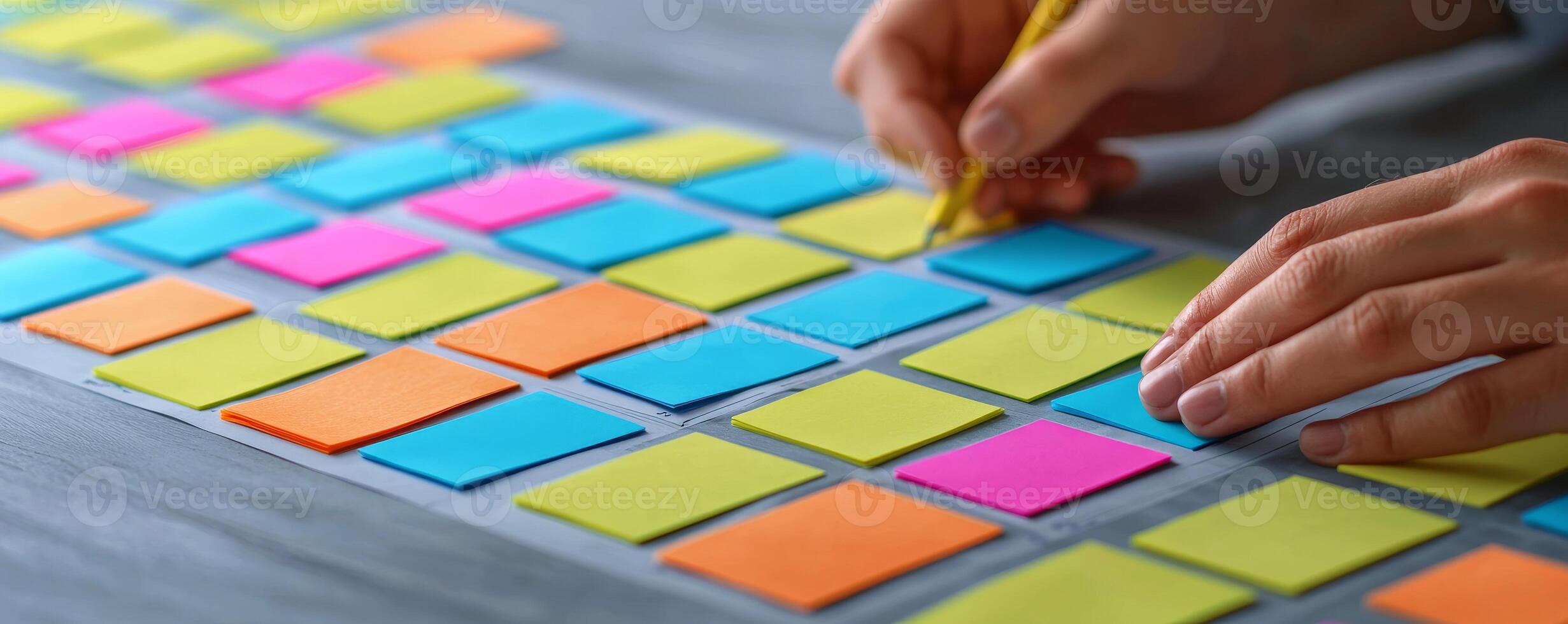 Project management coordination concept. Colorful sticky notes arranged on a surface with a person writing on one. photo