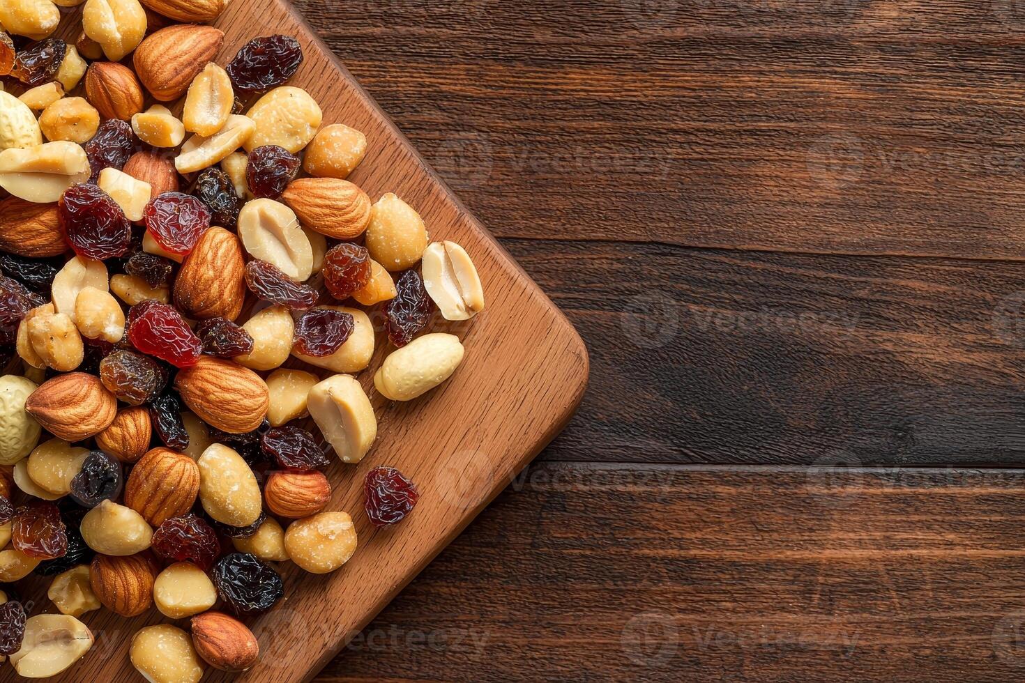 Nut trail mix with dried fruits concept. Assorted nuts and dried fruits on a wooden board background. photo