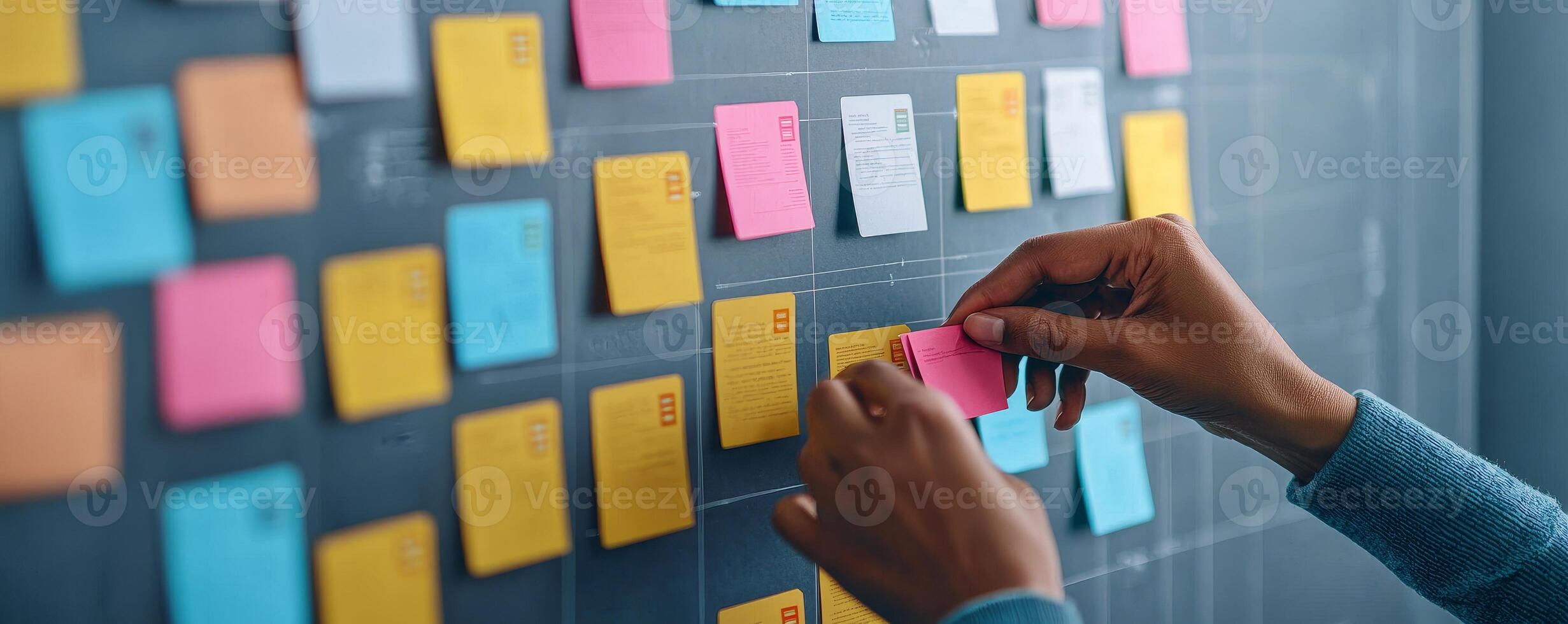 Productivity workflow execution concept. Hands placing colorful sticky notes on a wall for organization or brainstorming. photo
