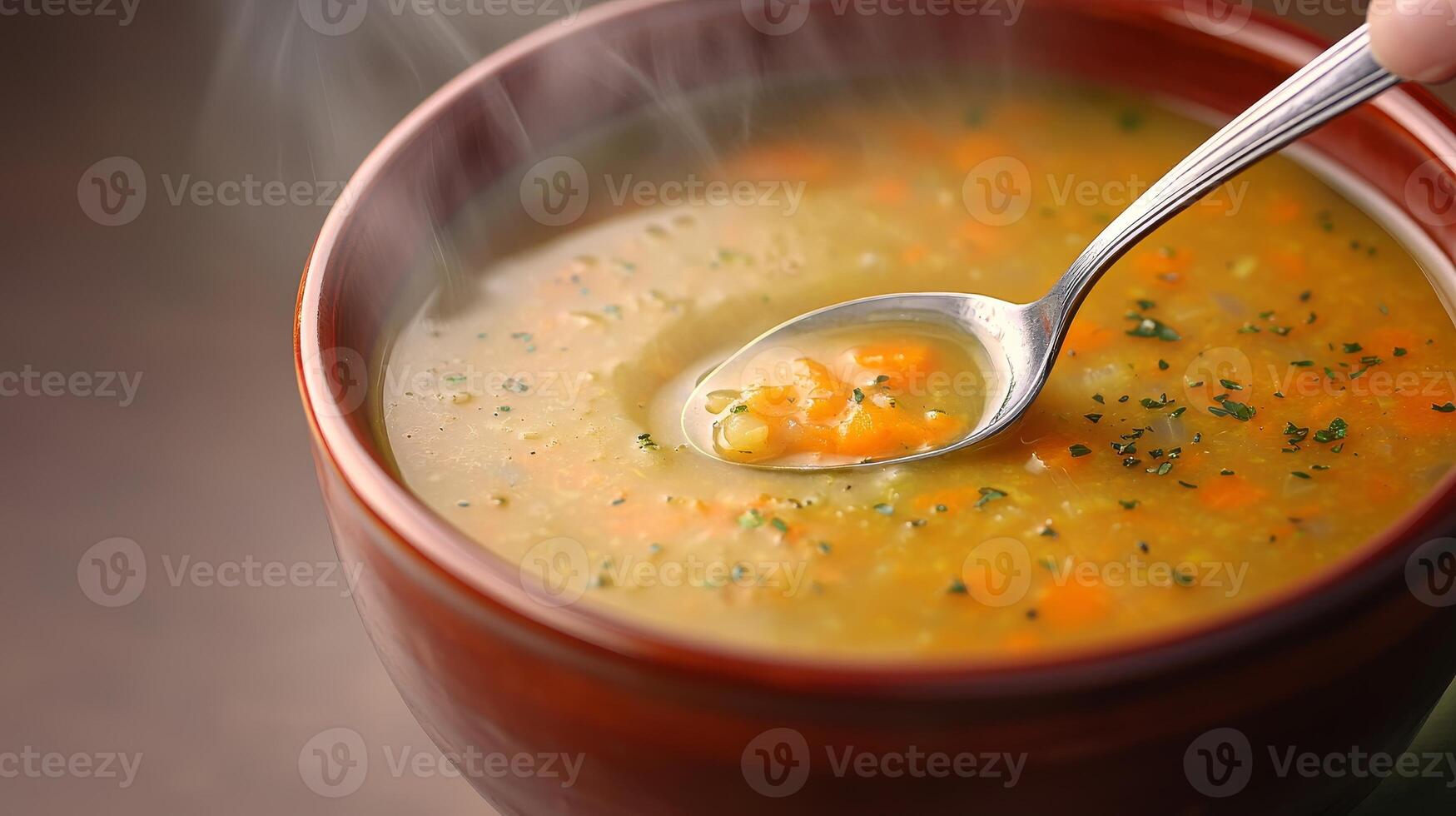 Carrot soup in ceramic bowl concept. A steaming bowl of delicious vegetable soup with a silver spoon. photo