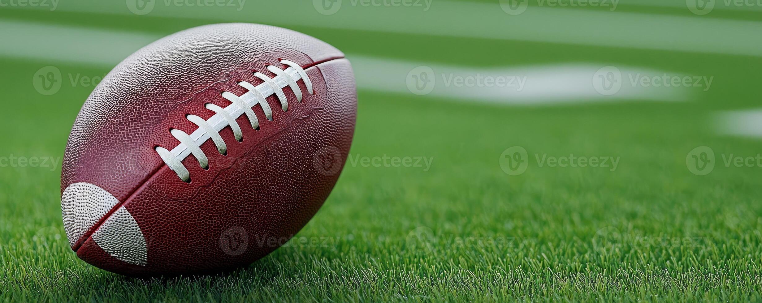 A close-up of a football resting on a green field, showcasing the textured surface and laces, emphasizing the sport's dynamic nature. photo