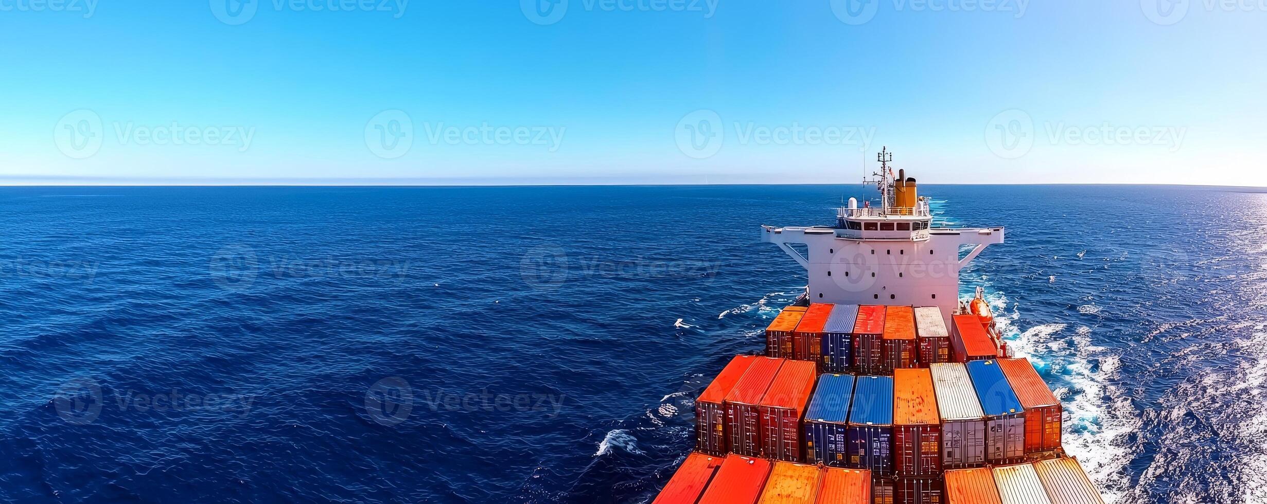 A cargo ship navigates through a vast ocean, showcasing colorful containers against a clear blue sky. photo