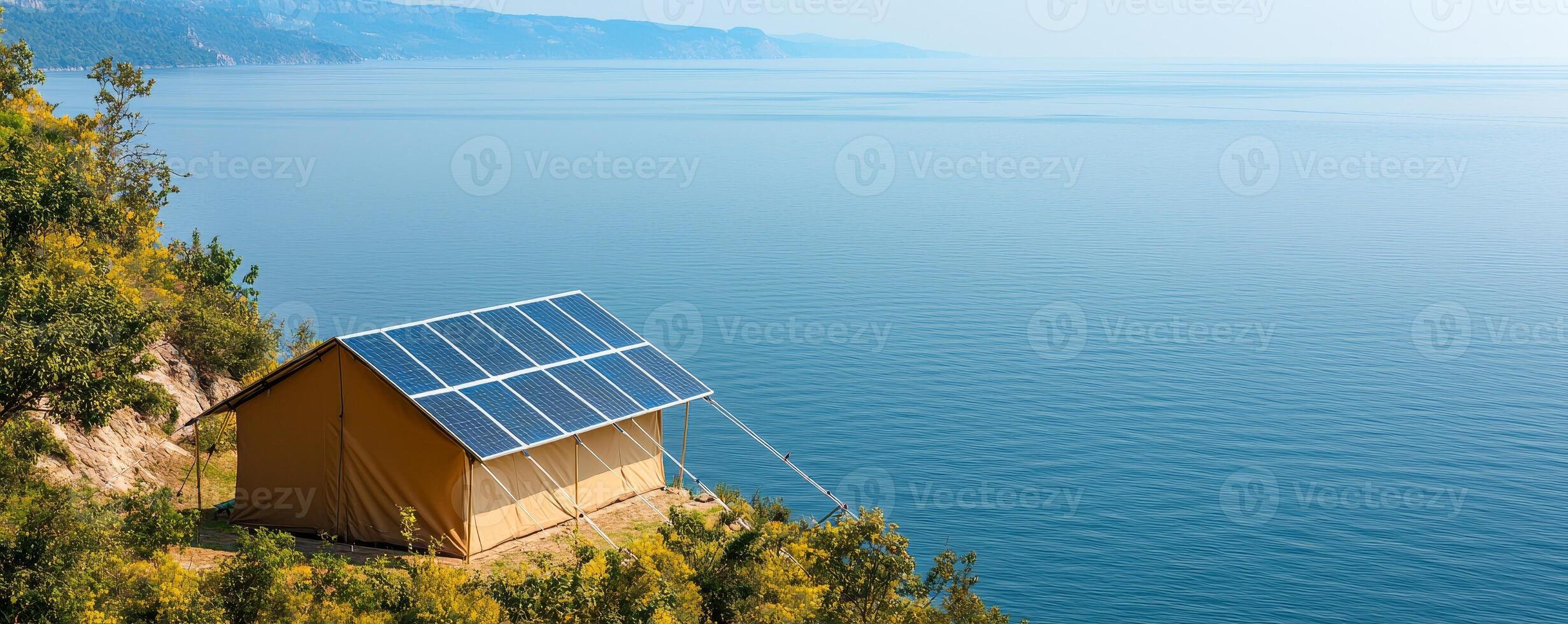 Adventure and Eco-tourism for travel concept. Tent with solar panels overlooks a calm sea, surrounded by lush greenery and mountains in the distance. photo