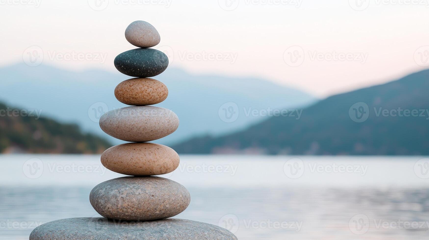 Social impact with justice concept. Stacked stones balancing by a serene lake with mountains in the background. photo