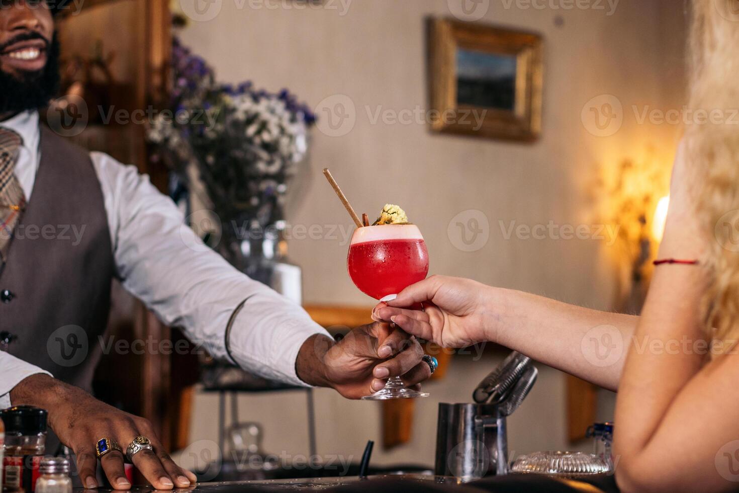 A man holding a drink in front of a woman photo