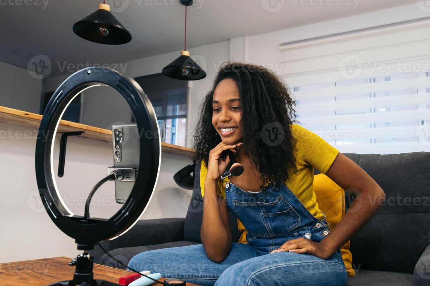 A woman sitting on a couch with a camera and microphone photo