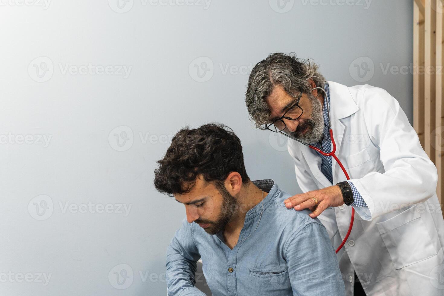 A doctor examining a man's chest photo