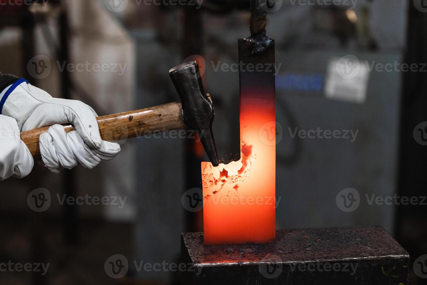 A person in a white glove holding an iron rod photo