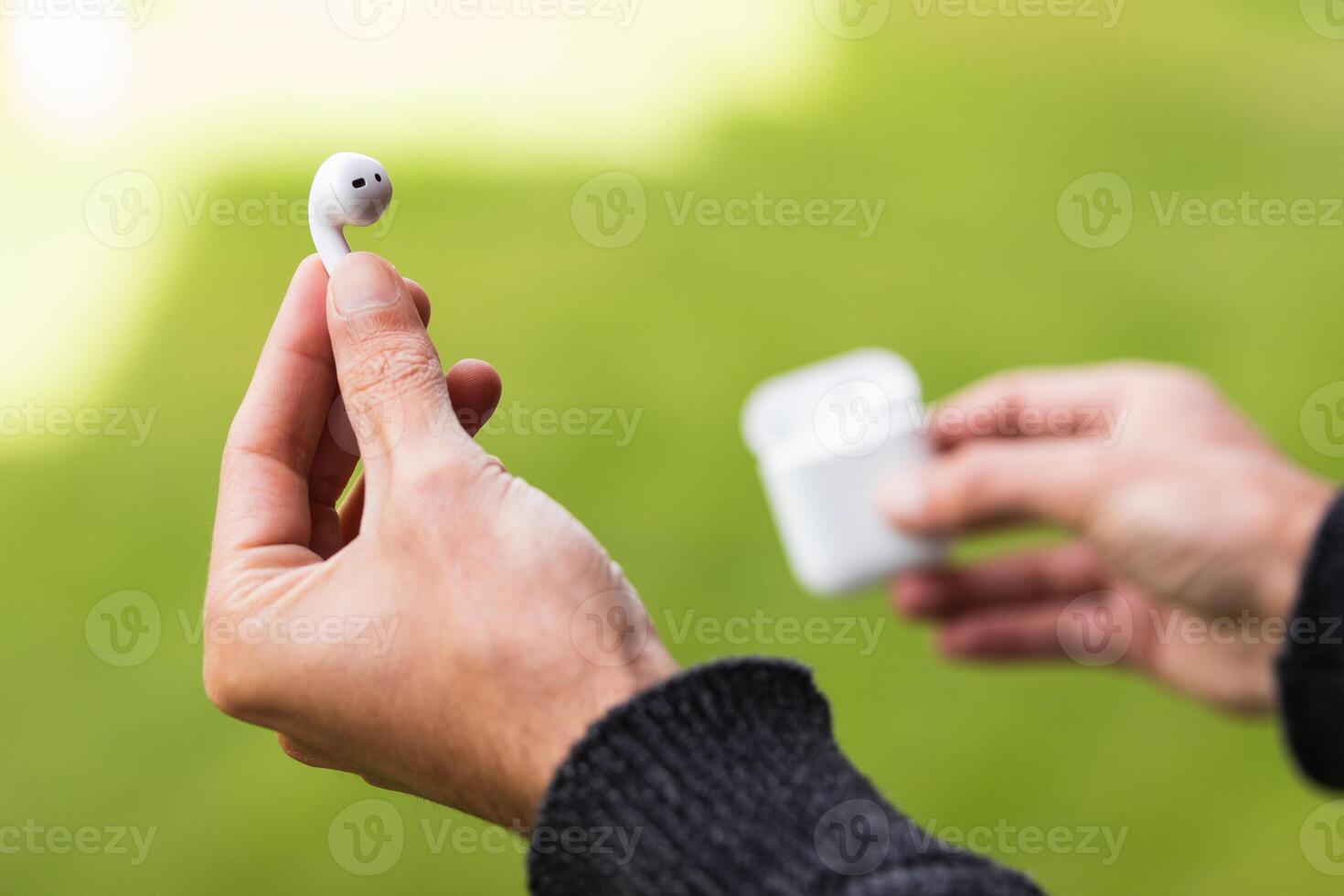 A person holding an apple airpods in their hand photo
