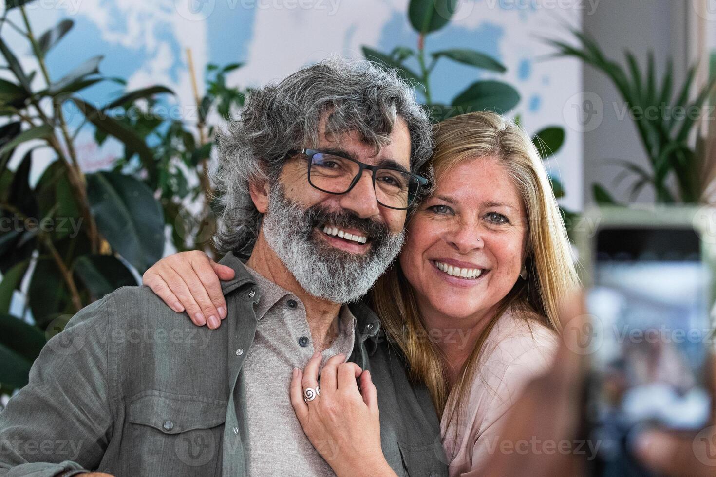 A man and woman taking a selfie with their cell phone photo