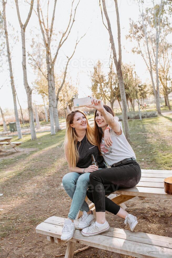 Smiling women taking selfie in park photo
