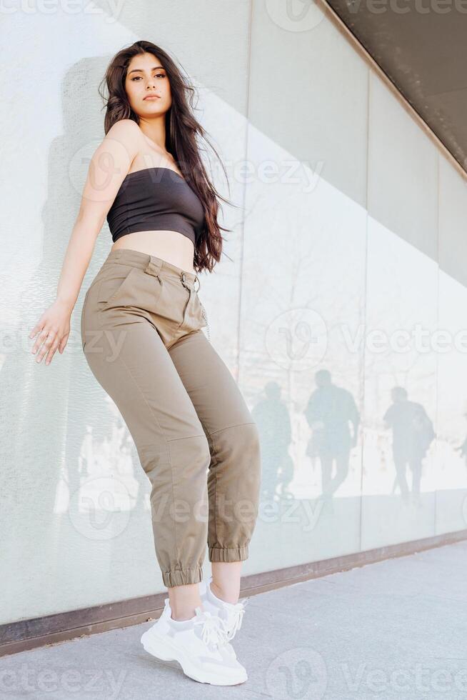 Beautiful female standing near wall photo