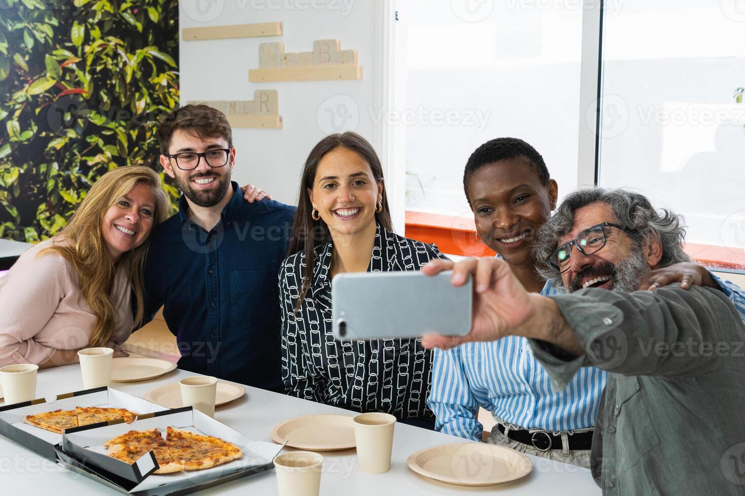 Cheerful multiethnic friends taking selfie during lunch photo