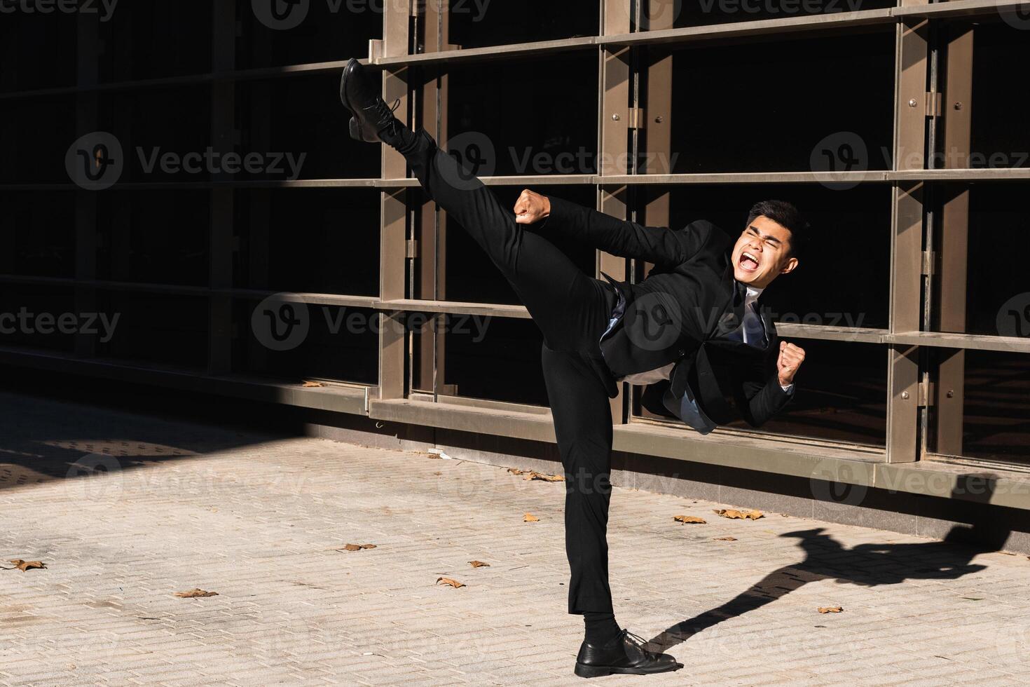 Businessman performing kick in air in street photo