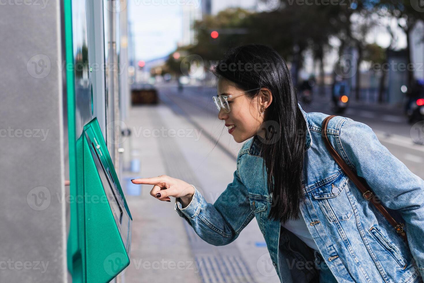 Long-haired brunette Chinese woman pulling out a train ticket at the station photo