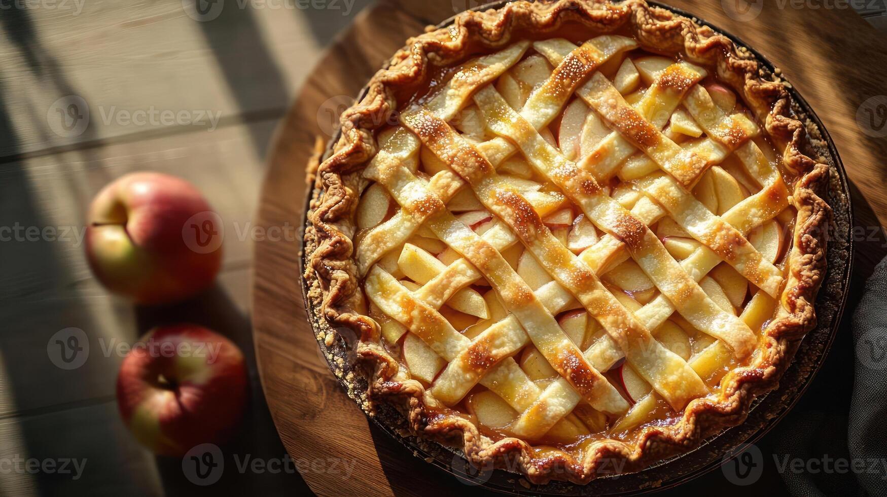 A lattice-patterned apple pie with three apples nearby photo