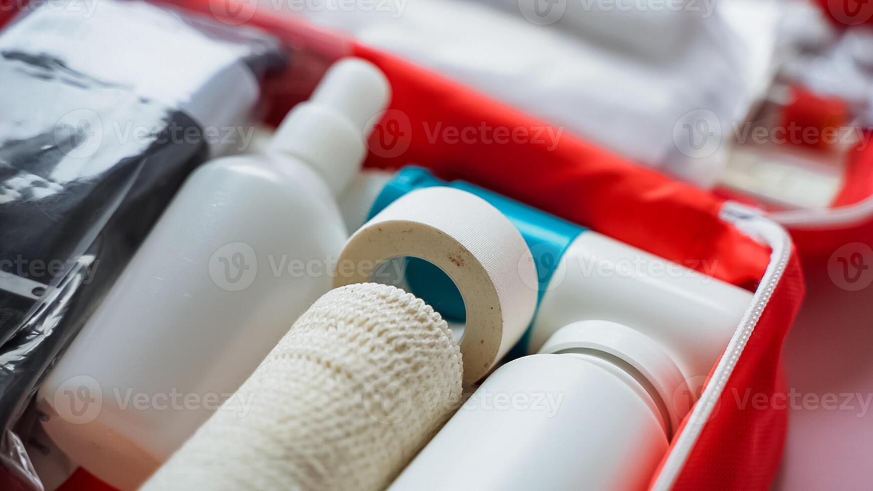 A bright red first aid kit, meticulously filled with various bandages, bottles, and a handy spray bottle, ensuring that you are prepared for any healthrelated emergencies that may arise photo