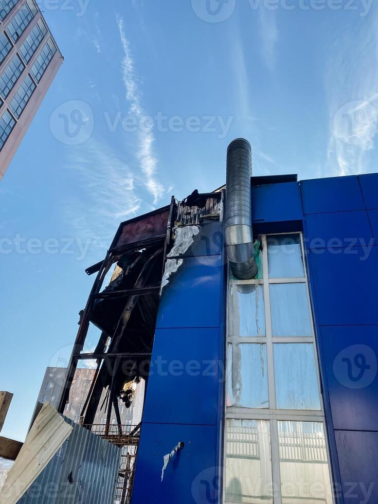 A striking blue building, which features a prominent chimney located on its side, showcases a modern architectural design that notably stands out and enhances the urban skyline photo