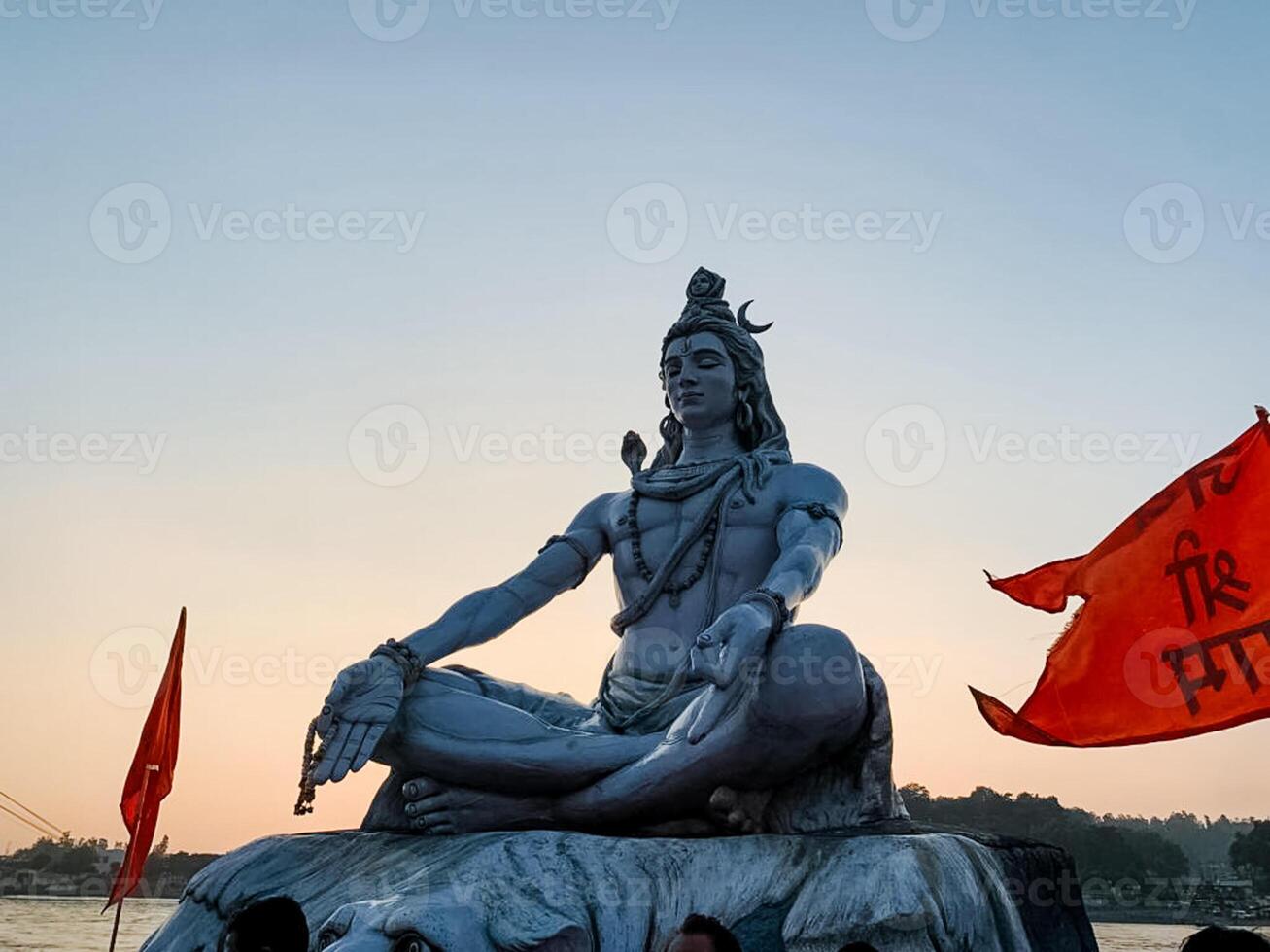 A stunning view of the towering Lord Shiva statue at sunset, adorned with vibrant flags and colors, evokes spirituality, peace, and deep devotion in all who see it photo