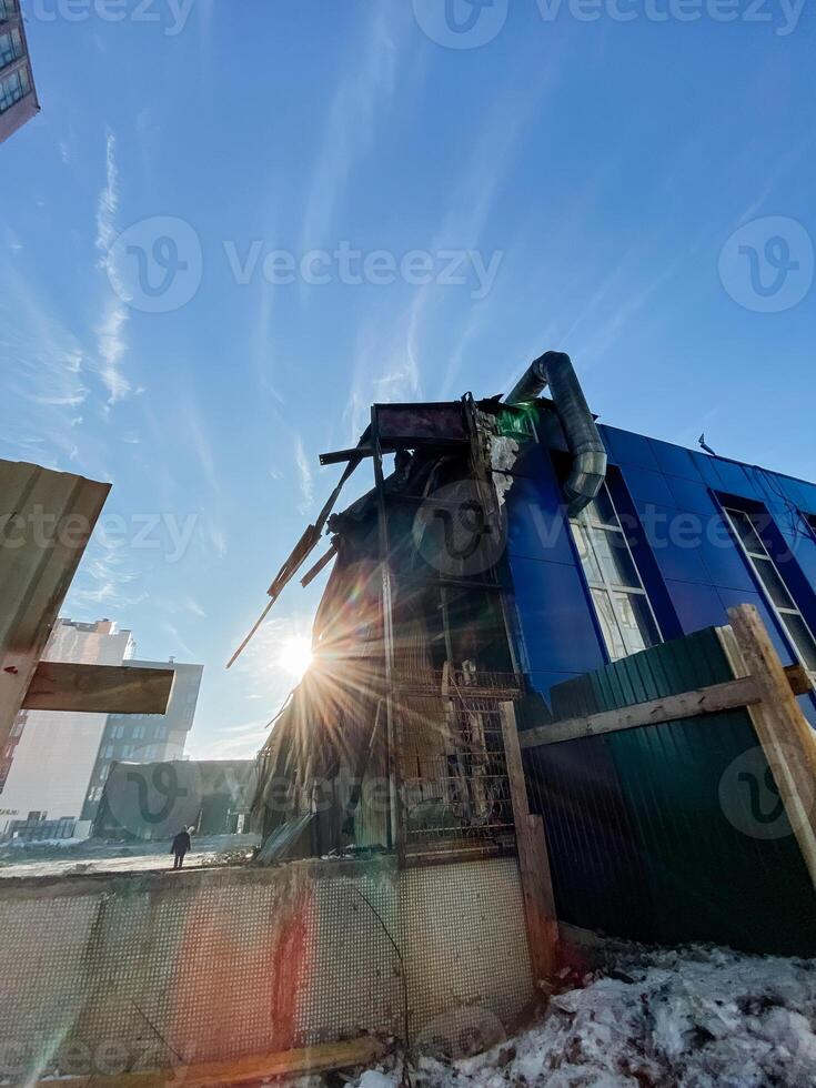 An abandoned structure defined by dramatic and striking lighting, nestled within an expansive urban landscape, captures attention with unique visual elements and textures photo