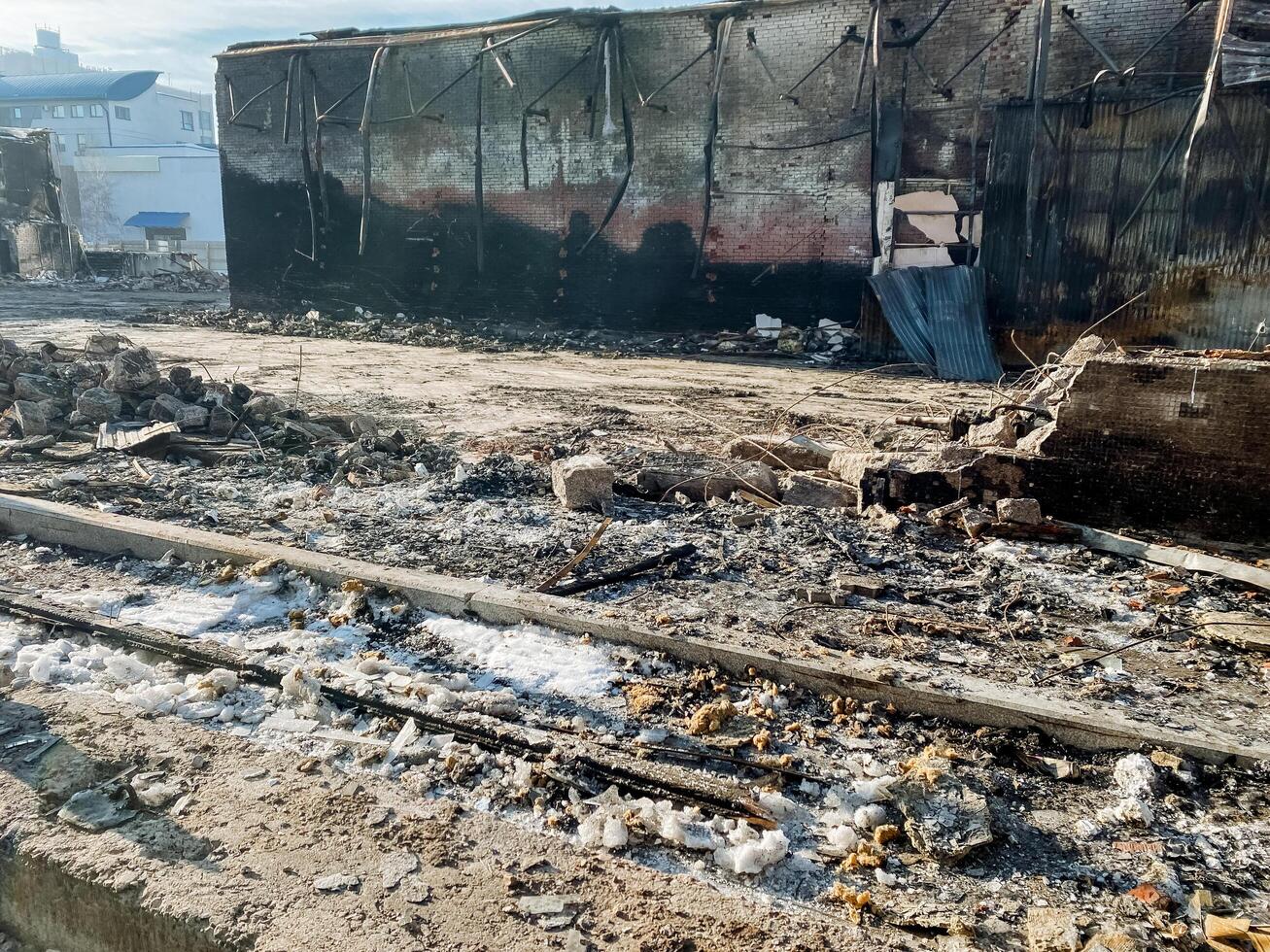 The Devastating Aftermath of a Fire Witness the Charred Remains and Scorched Earth Left Behind at a Burnt Structure, highlighting the complete destruction and loss photo