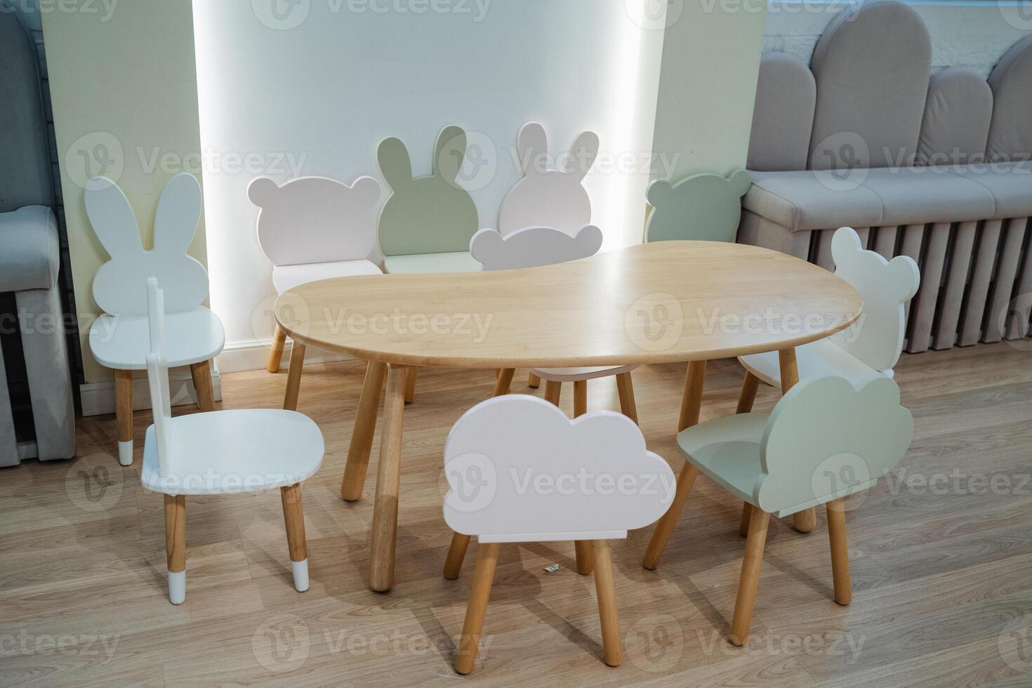 This cozy room features a beautifully crafted wooden table and matching chairs with animal silhouettes, creating a warm atmosphere ideal for relaxation and leisure activities photo