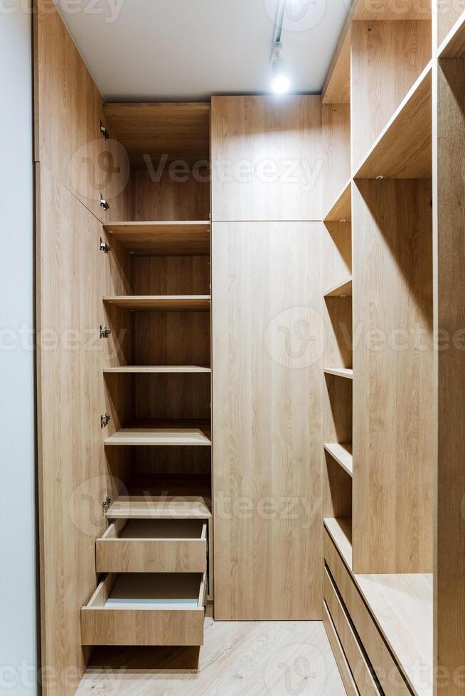 Experience the elegance and functionality of a modern wooden closet interior, featuring carefully designed shelving and drawers that ensure organized storage solutions photo