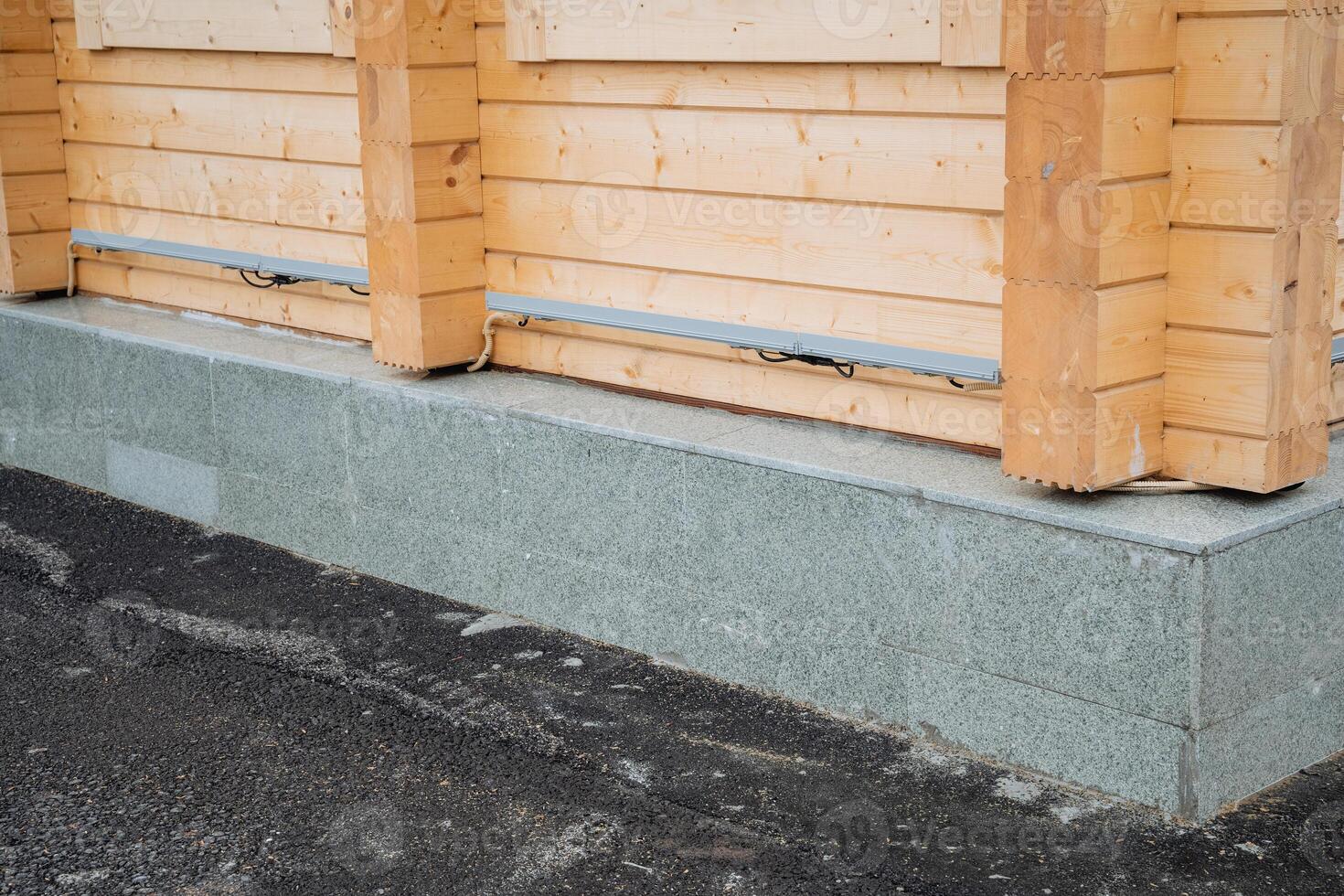 A wooden house is currently being built on a robust concrete foundation, which guarantees durability and stability, thus allowing it to withstand various challenging weather conditions photo