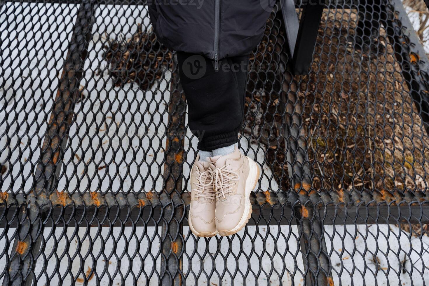A person is confidently standing on top of a sturdy metal fence, showcasing their balance and agility. The fence could be made from a variety of materials, including iron or wire photo