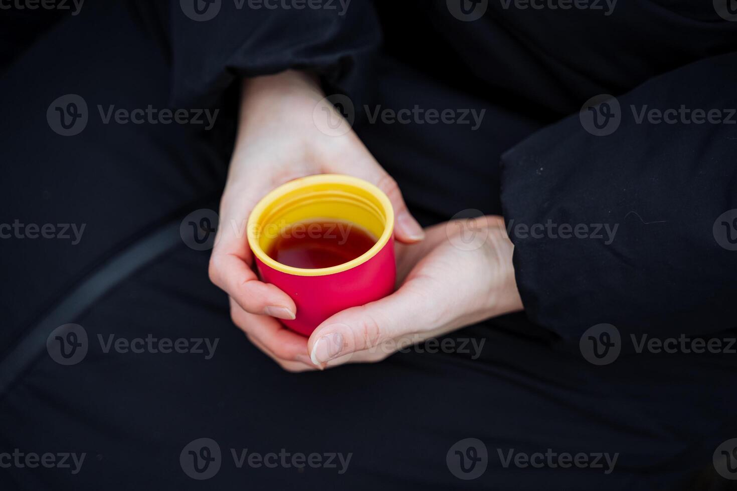 A person gently cradles a warm cup of deliciously fragrant tea, fully enjoying its enticing aroma and steaming warmth while savoring the calming, relaxing moment it brings to their day photo