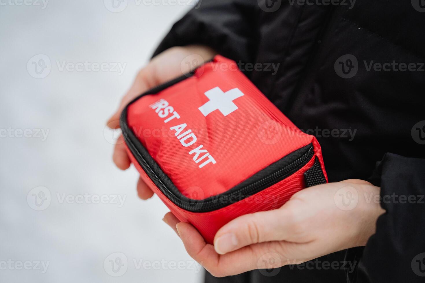 A person is carefully holding a bright red first aid kit in their hands, ready to provide assistance or emergency care when needed in various situations or healthrelated incidents photo