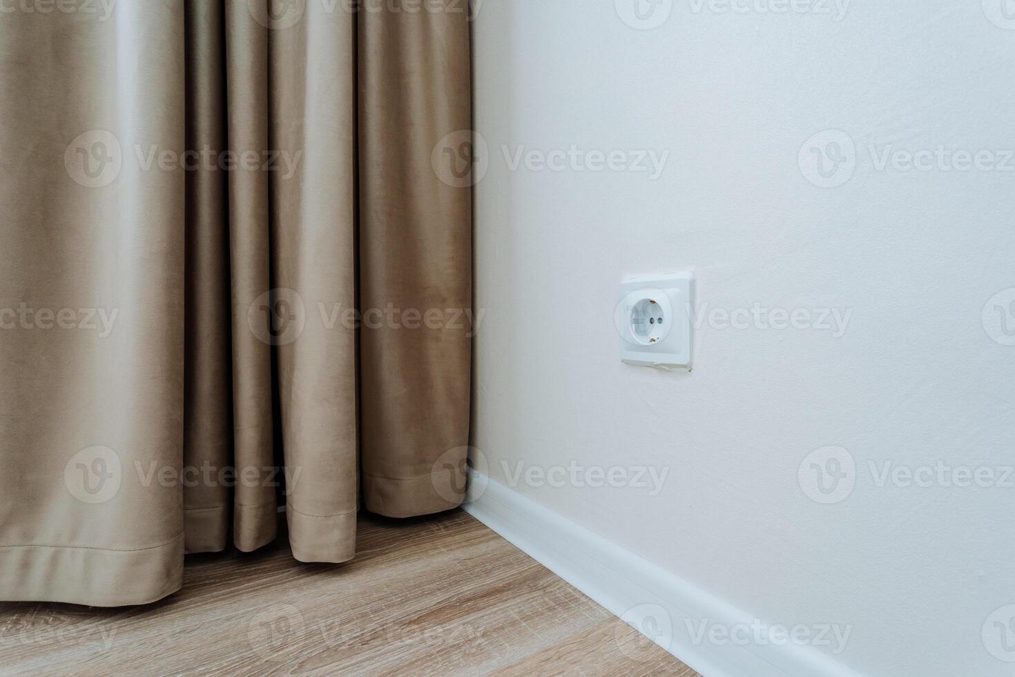 The interior of a bedroom featuring a decorative curtain and an electrical socket conveniently located on the wall, enhancing both functionality and style in the overall design photo