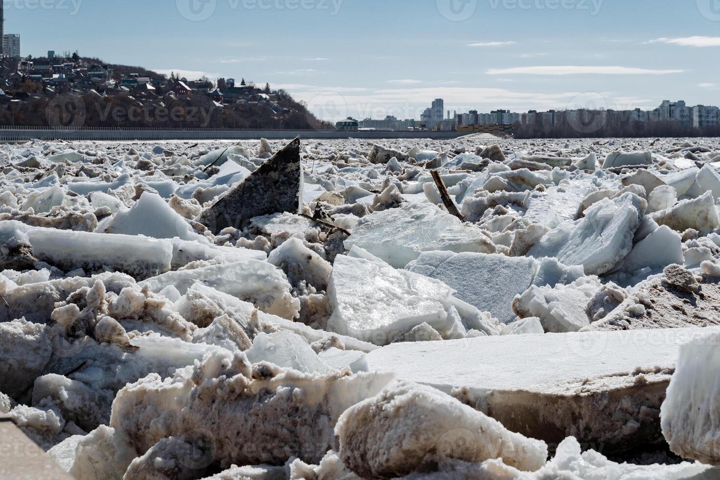 A large and impressive pile of ice is sitting peacefully on the shore of a serene lake, creating a stunning winter landscape. Its presence evokes a sense of cold beauty and tranquility photo