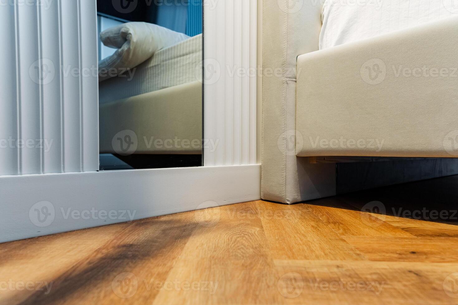 In this cozy bedroom, you will find a comfortable bed along with a stylish mirror beautifully mounted on the wall, creating a perfect space for relaxation and reflection photo