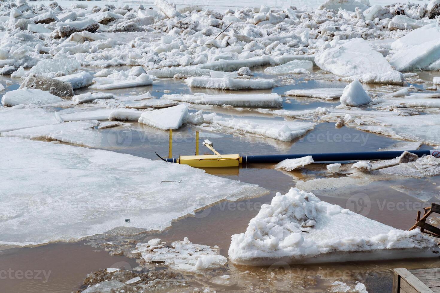 In a picturesque scene, a bright yellow boat is gently floating atop a puddle of ice, highlighting the striking contrast of color against the cold, icy landscape around it photo