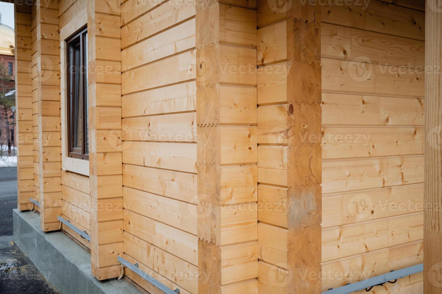 This image showcases a detailed closeup view of a wooden house that is currently under construction, emphasizing an unfinished window and the continuous effort being put into the project photo