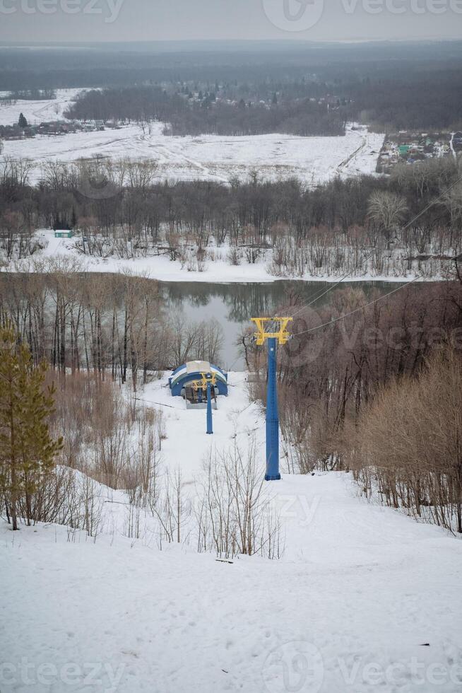 A ski lift is steadily ascending a snowcovered hill, providing a scenic and thrilling experience for winter sports enthusiasts enjoying the beauty of natures winter landscape photo