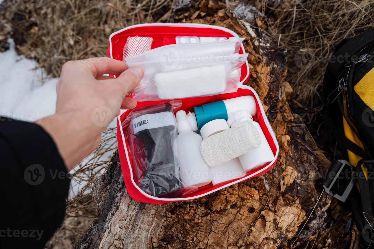 A person is currently holding a first aid kit firmly in their hand, ready to provide help or assistance. This kit is essential for addressing medical emergencies and injuries photo